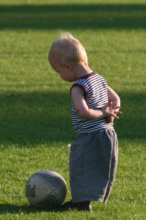 image illustrant un bébé contemplant une balle de rugby